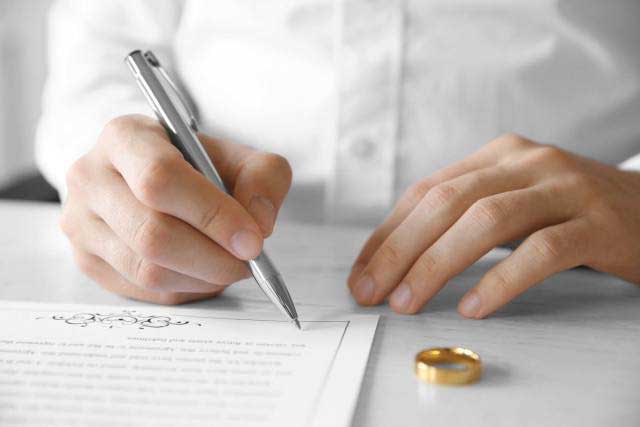 Man signing a divorce agreement
